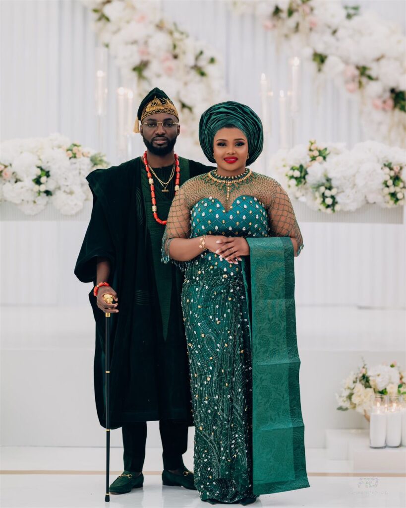 A bride and groom in a green traditional attire