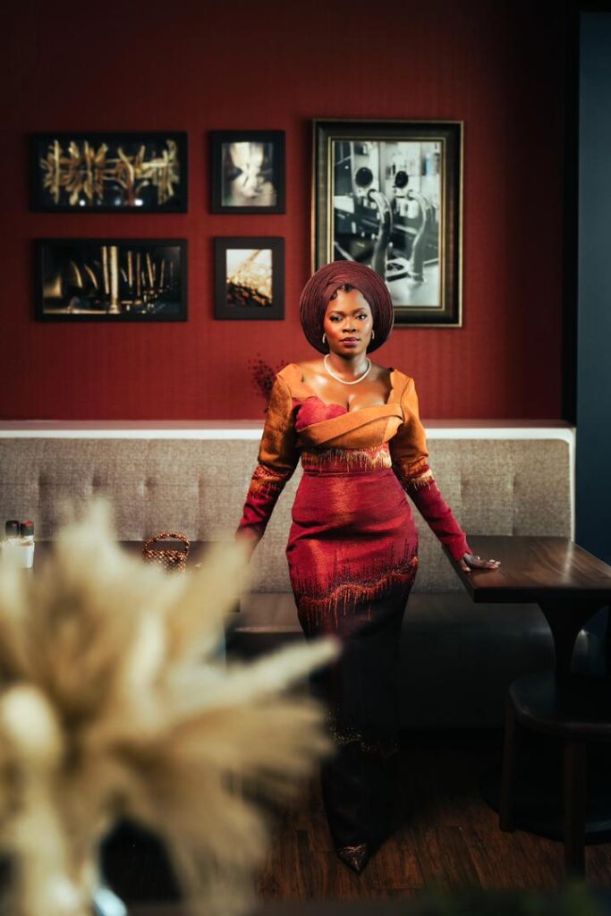 A bride in orange and wine asoebi